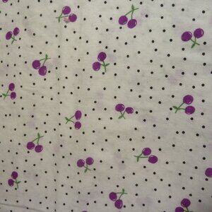 Fabric with purple cherry pattern green stems black dots white background